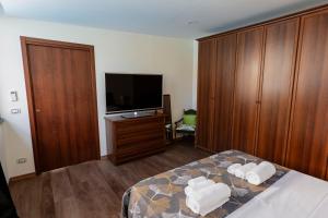 a bedroom with a bed and a tv and wooden cabinets at Luna di Sale - Romantic Sea Rooms & Apartments in Reggio di Calabria