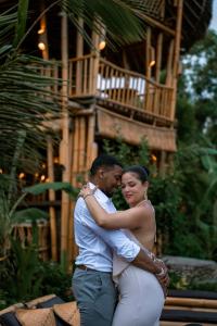 a man and a woman standing in front of a building at Penida Bambu Green Suites in Nusa Penida +37 photos