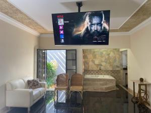 a living room with a tv hanging from the ceiling at Belíssima Casa Stella Maris -Casa de Carrara3 in Andradina