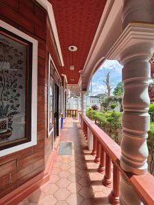 a porch of a building with columns and a painting at Red Stone villa in Masinagudi +27 photos