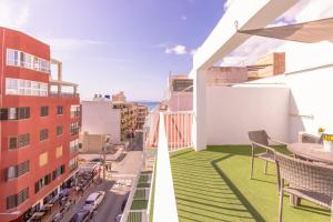 einen Balkon mit Blick auf eine Straße und Gebäude in der Unterkunft Hotel Boogaloo - Adults Only in El Arenal