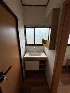 a bathroom with a sink and a window at 雲の家 旧東海道沿いの畑宿の温もりステイ in Hakone