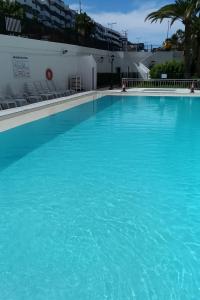 une grande piscine avec de l'eau bleue dans l'établissement Chic & Stylish near Yumbo, à Playa del Ingles