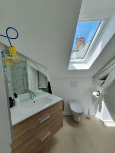 a bathroom with a sink and a toilet with a skylight at Du Peps au coeur d'Angers ! in Angers
