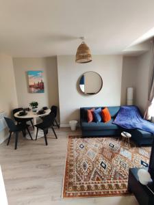 a living room with a blue couch and a table at Victoria's Bright Georgian Apartment in Liverpool +12 photos