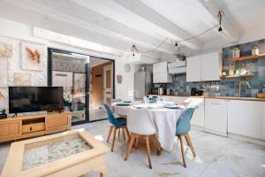 Le Tropical في لو غراو دو روا: مطبخ مع طاولة وكراسي وتلفزيون