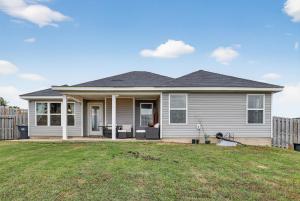 a white house with a fence in a yard at Peaceful Family Retreat Near Augusta home in Warrenville