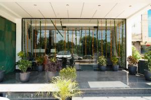 a store front with a window with potted plants at Hotel Score The Heaven in Zirakpur