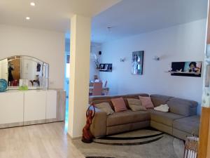 un salon avec un canapé et une cuisine dans l'établissement Appartamento Zaira, à Grosseto 11 autres photos