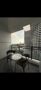 西哈努克SB Condo Sihanoukville -700m to U MALL的一间有一张桌子、两把椅子和一扇窗户的房间