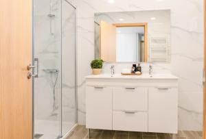 een witte badkamer met een wastafel en een douche bij LR Vintage 64 in Vila Real +13 foto's
