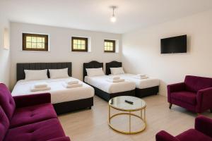 迪亚巴克尔Noen hotel的房间里有两张床、一张沙发和一台电视