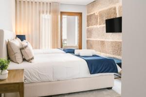 een slaapkamer met een bed en een bakstenen muur bij LR Vintage 64 in Vila Real