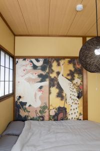 a bedroom with a painting of white birds on the wall at ミラージュ宿 2025年5月オープン 京都芸術 1軒家貸切 in Kyoto