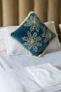 una almohada azul sobre una cama en The LUTF, en Nueva Delhi