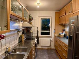 a kitchen with wooden cabinets and stainless steel appliances at Spacious Apartment in Sodermalm in Stockholm