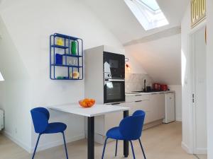a kitchen with a white table and blue chairs at Du Peps au coeur d'Angers ! in Angers