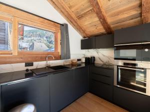 a kitchen with black cabinets and a large window at Chalet de charme rénové, centre Morzine, 4 pers, proche remontées mécaniques, parking inclus - FR-1-754-38 in Morzine