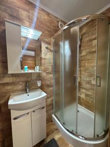 a bathroom with a shower and a sink at Residence Chalet & Nesh in Tatariv