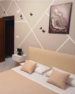 a bedroom with a bed with butterflies on the wall at Marruvium 1937 in Avezzano