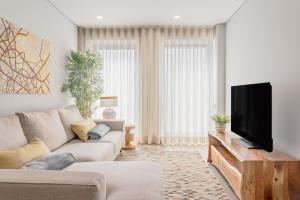 een woonkamer met een bank en een flatscreen-tv bij LR Vintage 64 in Vila Real
