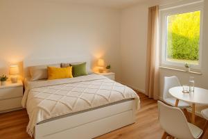 a bedroom with a bed and a table and a window at Dat Fischerhuus in Pruchten