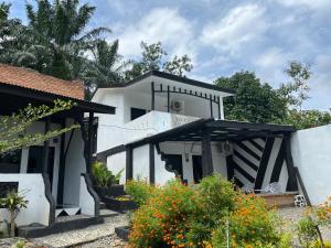 a white house with a staircase leading to it at Bukit Lawang Orangutan Dormitory in Bukit Lawang
