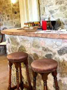 two wooden stools sitting at a stone counter at Villa Tiberini - Casale Il Pecino in Osteria Delle Noci