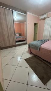 a bedroom with a bed and a large mirror at Casa da Portuguesa in Joinville