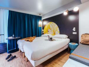 a hotel room with two beds and a laptop on the bed at ibis Styles Le Treport Mers Les Bains in Mers-les-Bains