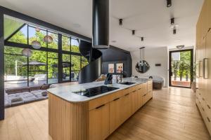 cocina con fregadero y ventana grande en Midnight Raven Lake House - luxury a-frame w boat, en Reed Creek