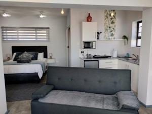 a living room with a couch and a bedroom at Driftwoods in Gqeberha