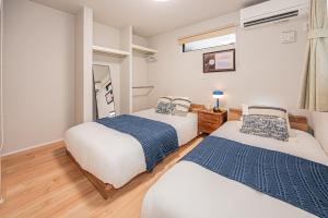 a bedroom with two beds and a mirror at Mi-Villa SHIBUYA HONMACHI in Tokyo