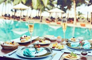 uma mesa com pratos de comida e taças de champanhe em Jetwing Beach em Negombo