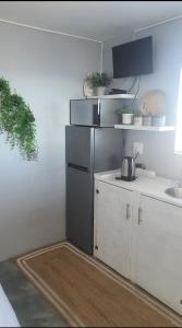 a kitchen with white cabinets and a sink at View on the Bay 7 Pinta Crescent in St Helena Bay