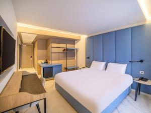 a bedroom with a large white bed and blue walls at Mercure St. Julian's Malta in St Julian's