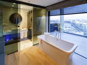 a large bathroom with a tub and a shower at Mercure St. Julian's Malta in St Julian's
