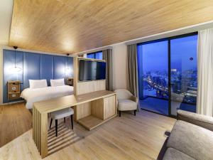 a hotel room with a bed and a desk with a television at Mercure St. Julian's Malta in St Julian's