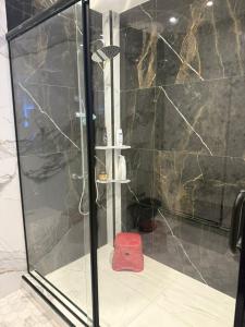 a shower with a red stool in a bathroom at Résidence montana in Deli Ibrahim +9 photos