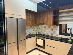 a kitchen with white cabinets and black counter tops at Résidence montana in Deli Ibrahim