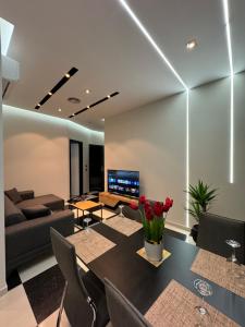 a living room with a table and a couch at Modern Sueno Lux Apartments in Tirana