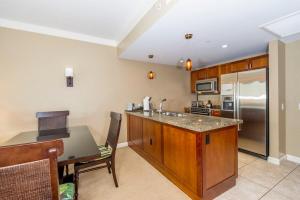 una cocina con encimera y refrigerador en Honua Kai 1024 · HK 1024 Updated Beachfront Luxury Condo w Pool, en Lahaina