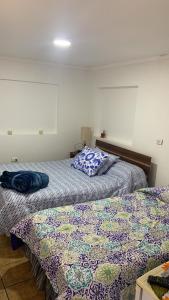 twee bedden naast elkaar in een slaapkamer bij Ghislaine in Iquique