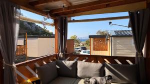 a dog laying on a couch on a balcony at Mobile home MARIS in Sveti Juraj +32 photos
