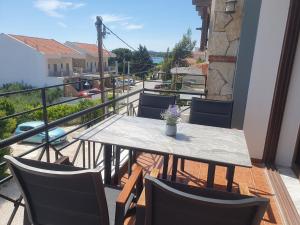 Una mesa y sillas en un balcón con vista. en Teo`s Seaview Apartment Nikiti, en Nikiti