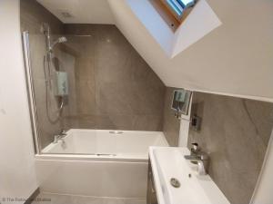 a bathroom with a white tub and a sink at The Stables in Droitwich +23 photos