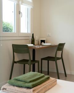 a kitchen with two green chairs and a table at Sassimori casa vacanza in Chiampo
