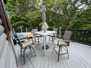 a table with chairs and an umbrella on a deck at Hidden gem at the lake 4 bedrooms in Moneta