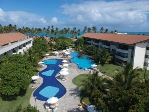 an aerial view of a resort with pools and umbrellas at Praia dos Carneiros, Flat com Vista Mar, 2 quartos, em Resort de Luxo in Tamandaré