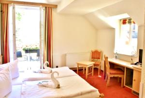 2 cygnes assises sur les lits d'une chambre d'hôtel dans l'établissement Hotel Alttolkewitzer Hof, à Dresde